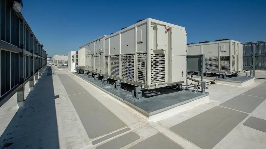 Row of packaged rooftop units along a building parapet