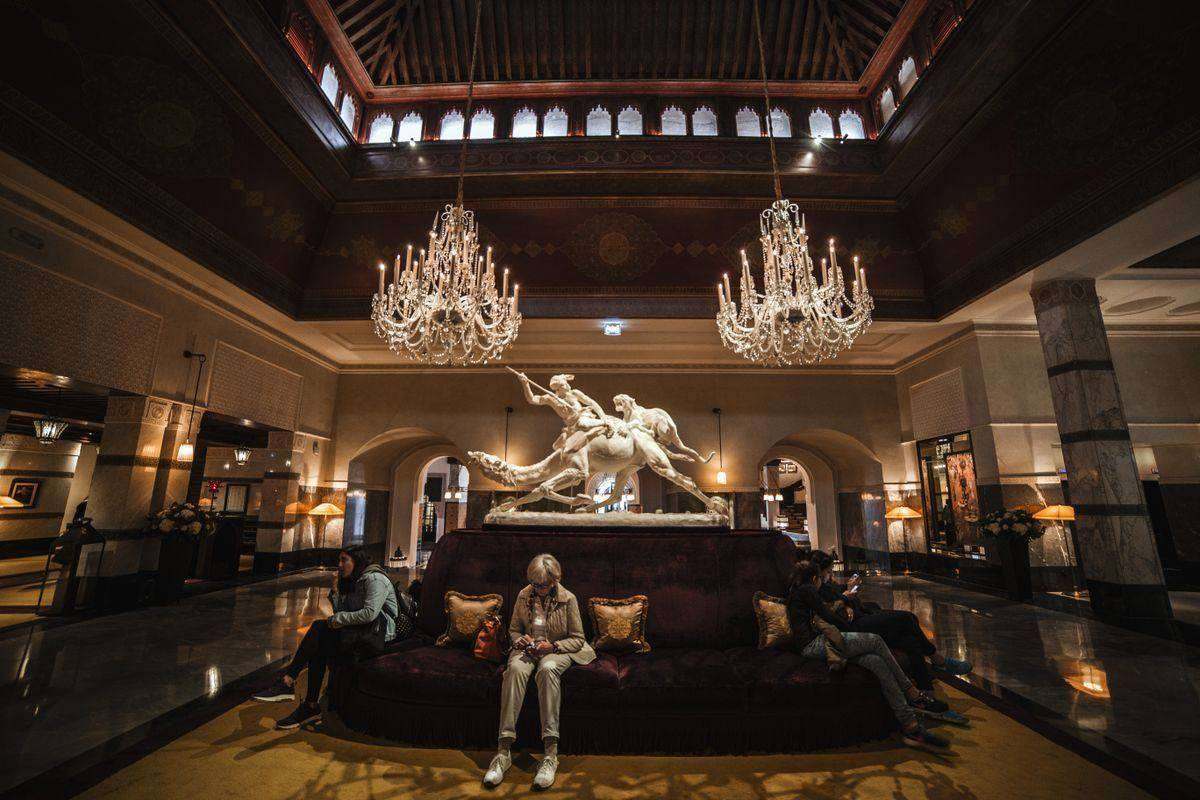 Spacious, well-lit modern luxury hotel lobby interior with warm ambient lighting and contemporary furnishings